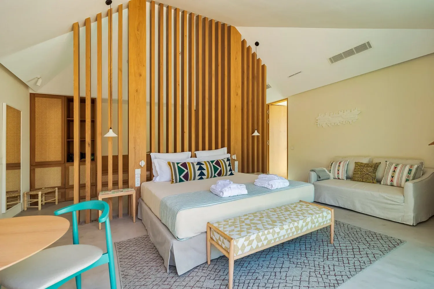 Dormitorio de villa en Spatia Comporta con carpintería de listones de madera y mobiliario a medida de Uood